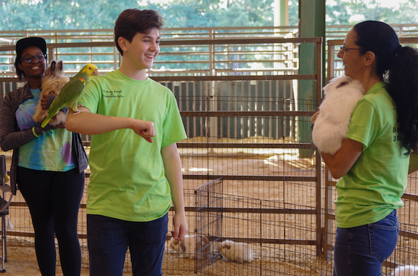 Photo of 3 people with animals from petting zoo